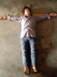 酷刑演示：法輪功學員被綁在「十字」架上