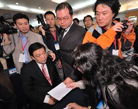 圖：中共北京副市長吉林在數百人的會場上，對遞到眼前的訴狀，一臉愕然