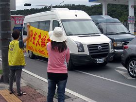 法輪功學員向楊松車隊舉橫幅，抗議迫害法輪功