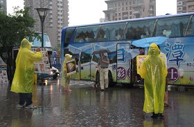 六月二十六日下午受到米雷颱風外圍環流影響，下起了大雨。法輪功學員們一個也沒離開，穿起雨衣繼續拿展板講真相。