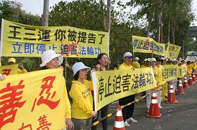 台南市議員曾秀娟（左三）聲援法輪功，一起拉橫幅對王三運大聲呼口號。
