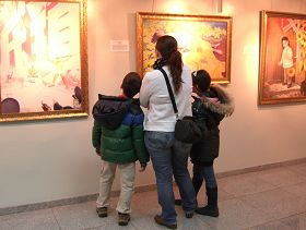 參觀者們聚精會神地觀賞畫展作品