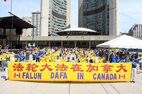 加拿大多倫多的法輪功學員與支持法輪功的各界人士一起，在多倫多市府前的彌敦爾•菲利浦廣場舉行大型集會和集體煉功慶祝世界法輪大法日