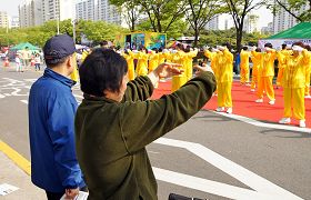 韓國法輪功學員在博士谷藝術節慶典上演示功法，市民也跟著學煉動作