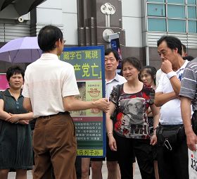 一零一大樓景點前的真相展板圍著層層的中國遊客爭相了解事實、聽學員講真相