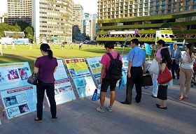 七月二十日下午，各國遊客觀看韓國法輪功學員在首爾廣場展出的真相展板。