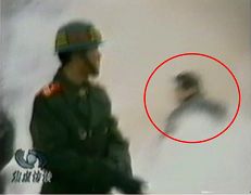 CCTV「自焚」節目慢動作分析-4：一名身穿大衣的男子正好站在出手打擊的方位，仍然保持著一秒鐘前用力打擊的姿勢