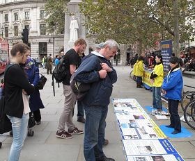 '法輪功學員在倫敦聖馬丁廣場揭露中共活摘法輪功學員器官罪行，吸引眾多民眾駐足了解真相。'