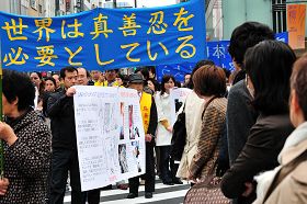 日本法輪功學員遊行紀念「四•二五」，經過東京繁華街頭，許多市民駐足觀看