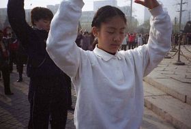 一九九九年四月初，幾個煉功點的近千名法輪功學員在瀋陽和平廣場晨煉──煉功人群中的小學生。