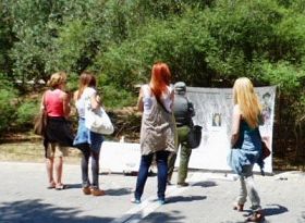 '希臘學員在雅典的衛城博物館旁舉辦信息日活動。不少遊人駐足觀看，了解法輪功真相。'