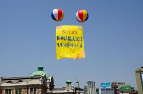 活動現場首爾站上空飄揚著「慶祝法輪大法洪傳20週年」的大型氣球。