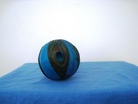 孔雀翎球直徑約10cm（製作第一步是把白色泡沫做的圓球去掉多餘部份，磨平，然後塗上黃膠，把染上藍色的可能是鵝毛粘在球上，再把四個孔雀毛塗上膠粘上）