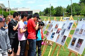 來自中國大陸的中學生爭相閱讀介紹法輪功和反迫害的真相展板，索要真相資料，並拍照錄像。