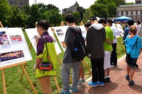 來自中國大陸的中學生爭相閱讀介紹法輪功和反迫害的真相展板