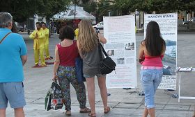 遊客在雅典市中心中央廣場閱讀法輪功真相展板