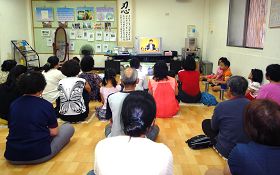 親子學法煉功班，學員們正觀看李洪志老師講法錄像帶。