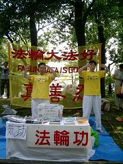法輪功學員在稻澤市第十七屆夏季活動節展位上煉功