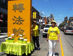 吳豔霞（右）參加二零一二年多倫多慶祝法輪大法日大遊行經過唐人街