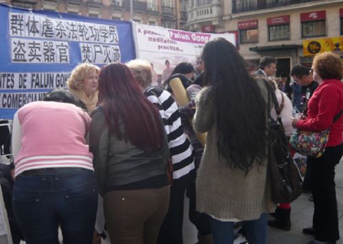 西班牙民眾及遊客觀看中共迫害法輪功學員的展板圖片