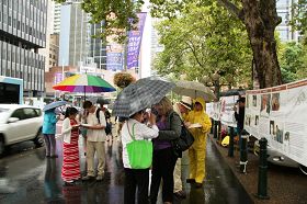 悉尼部份法輪功學員冒雨在市政廳大樓前舉辦徵簽活動