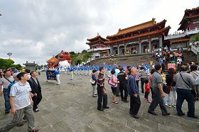 '天國樂團在文武廟廣場演奏，一團一團的遊客正經過觀看，其中有很多來自大陸的遊客。'