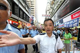 '圖3：香港警方不但阻止市民接近了解法輪功真相，還阻擋媒體採訪拍照。'