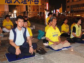 '圖2，立法委員劉建國（左一）與法輪功學員並肩悼念默哀'