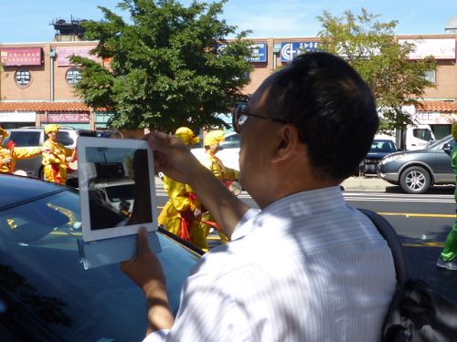 華人人用I-Pad記錄法輪功遊行的震撼場景。