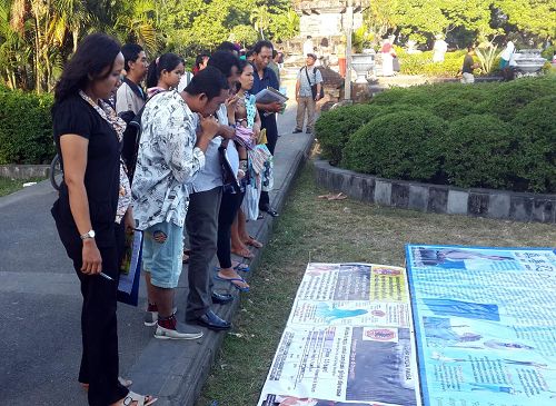 '巴釐島登巴薩市Pupudan Badung公園裏，人們認真閱讀法輪功真相展板'