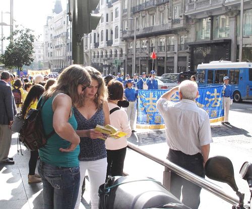 圖2：二零一四年十月四日，法輪功學員在馬德裏舉行盛大遊行，很多人接過真相傳單，認真閱讀