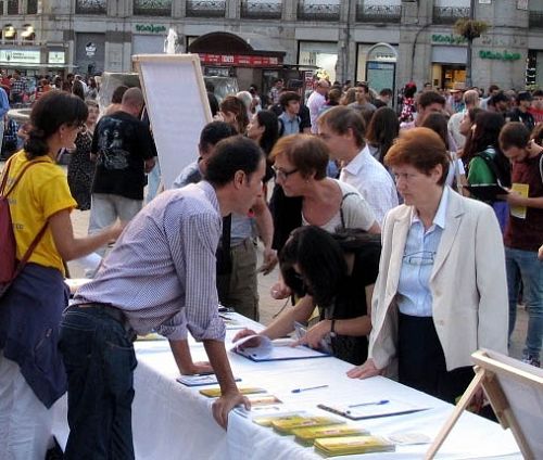 圖5：二零一四年十月三日傍晚，在馬德裏市中心的太陽門廣場，一位西班牙女士認真了解法輪功真相，並簽名譴責中共活摘器官