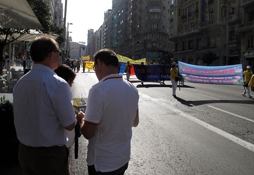 圖11：電器工程師馬克羅（Macro）和安吉爾（Angel）在馬德裏大街上認真觀看法輪功學員的反迫害大遊行