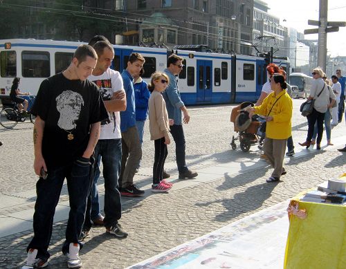 圖：阿姆斯特丹的達姆廣場上，遊人認真了解法輪功真相