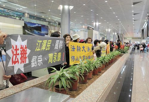 '中共海協會長陳德銘來台，法輪功學員在機場舉橫幅反迫害。'