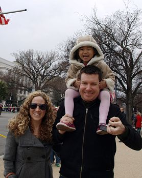 圖3：凱瑟琳和先生帶著從中國領養的四歲的阿麗斯觀看遊行