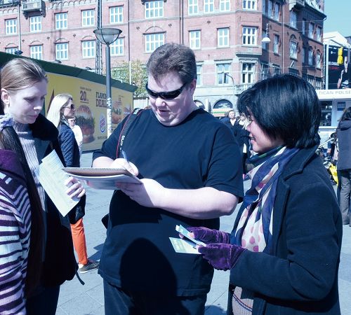丹麥哥本哈根市政廳廣場，遊客簽名譴責中共迫害法輪功
