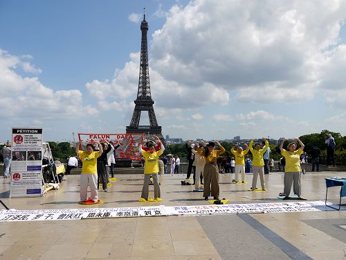 圖1-5：巴黎學員在著名景點埃菲爾鐵塔下的人權廣場傳播法輪功真相，吸引四方來客駐足了解。