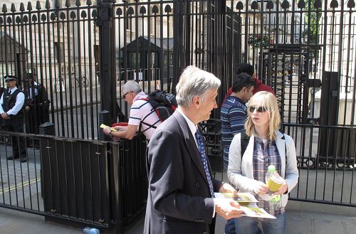 法輪功學員在英國首相府前，跟前來看熱鬧的人們講述法輪功的真相。