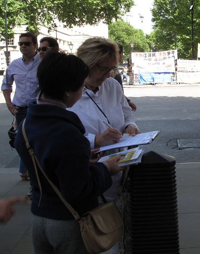 六月十七日下午，路過唐寧街大門外的英國女士傑西（Jesse）在反活摘徵簽表上簽名
