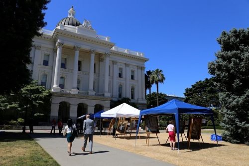 圖1：法輪功學員於二零一四年六月三日和四日，在加州首府沙迦緬度州議會大廈北草坪上舉辦活動，展示畫作，傳播真相。