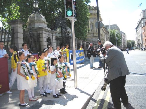 圖1：愛爾蘭法輪功學員的遊行隊伍在愛爾蘭議會大樓門前暫留，愛爾蘭主流媒體報紙的攝影記者給遊行隊伍拍照。