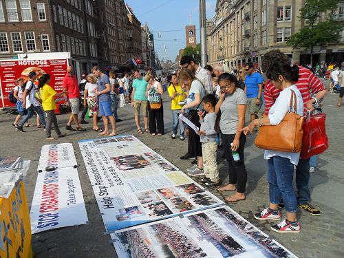 紀念和平反迫害十五週年，荷蘭學員在阿姆斯特丹著名的達姆廣場設立真相點，大批遊人駐足閱讀真相圖片，了解真相。