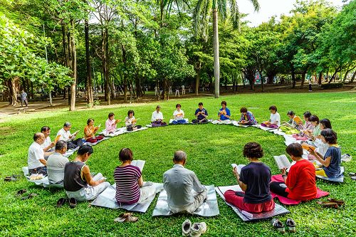 在台南東寧公園中央大草地上，法輪功學員煉完五套功法後，繼續一起學法一個半小時。