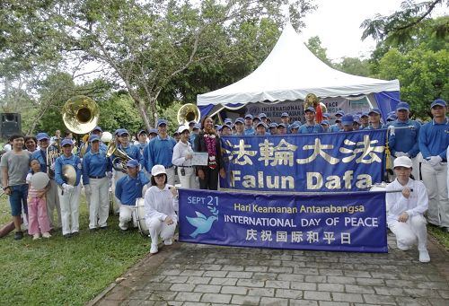 法輪功學員組成的天國樂團與聯合國駐馬來西亞協調員蜜雪兒（中間戴花者）開心合影
