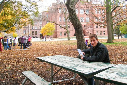 圖3：卡爾頓大學的大學生Sam Rubimosi先生坐在長凳上觀看法輪功學員的集體煉功。
