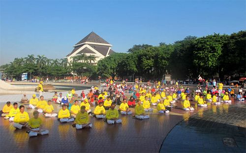 數百法輪功學員身著黃色T恤來到主入口附近的紀念碑前集體煉功