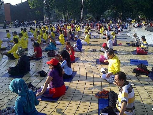 印尼民眾和身著黃色T恤的法輪功學員一起打坐