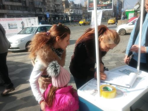 一位帶著兩個女兒的母親在簽名