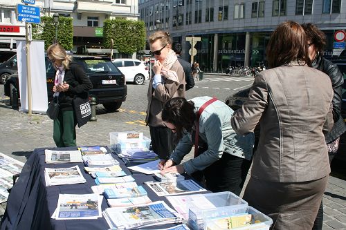 圖1-3：在歐洲議會大廈前舉辦講真相活動，很多民眾在「反對活摘法輪功學員人體器官的徵簽簿」上簽名